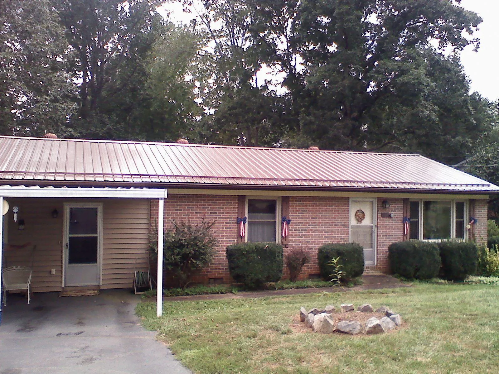 Bronze metal roof and carport on a brick ranch home — Roof Repair work by our crew in Boothbay